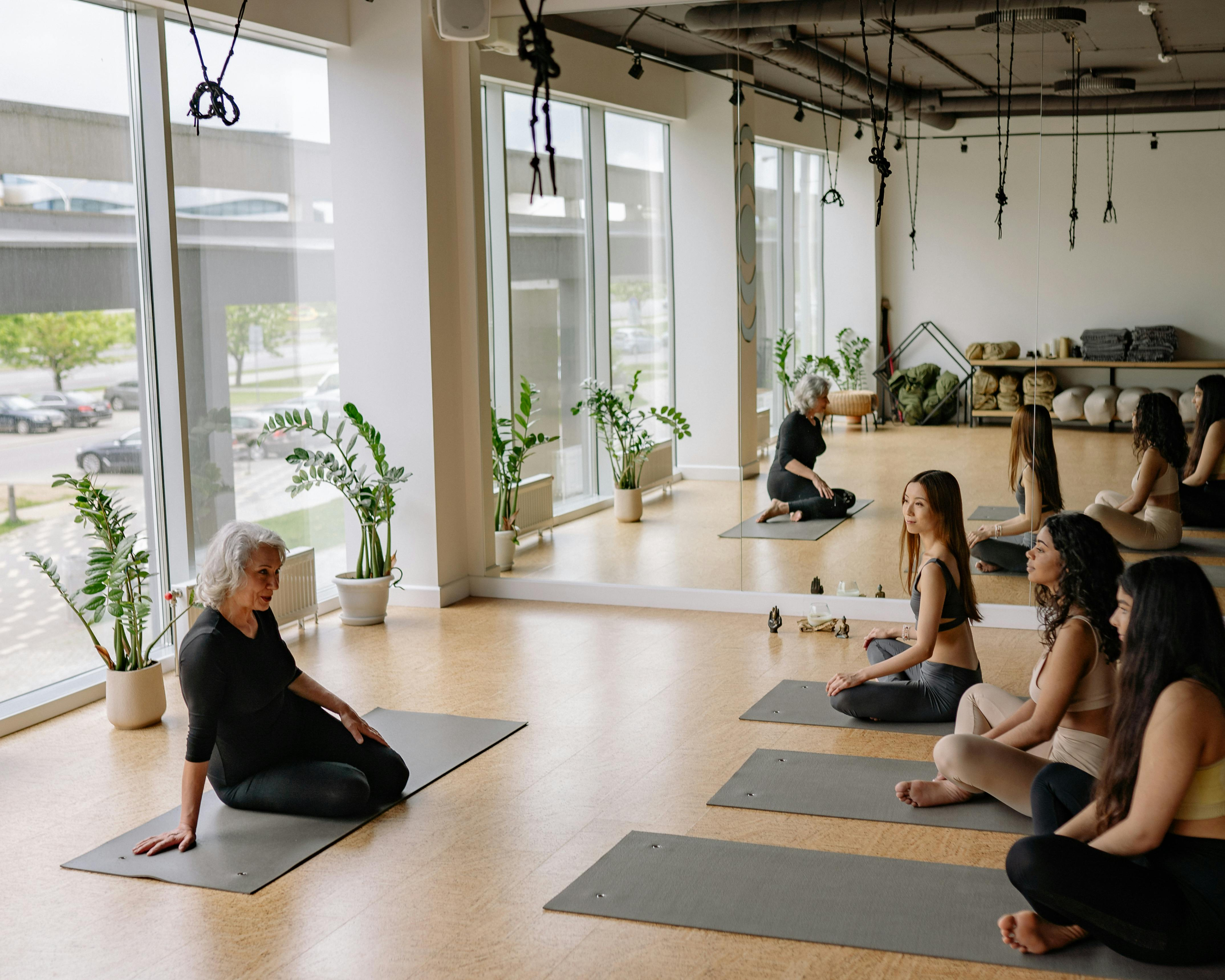 Yoga instructor supporting a student in class